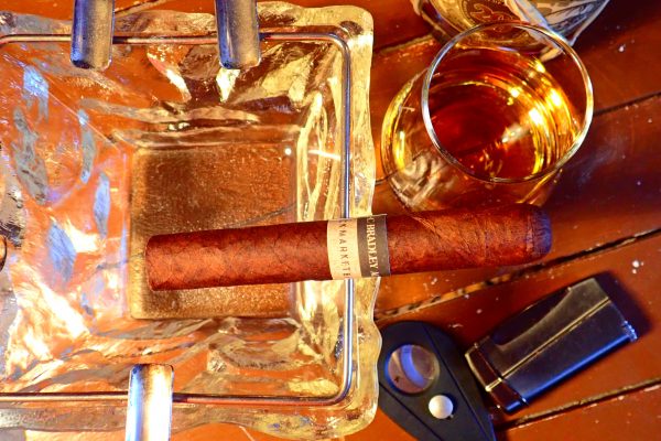 Zigarre im Aschenbecher mit Rumgals und Flasche